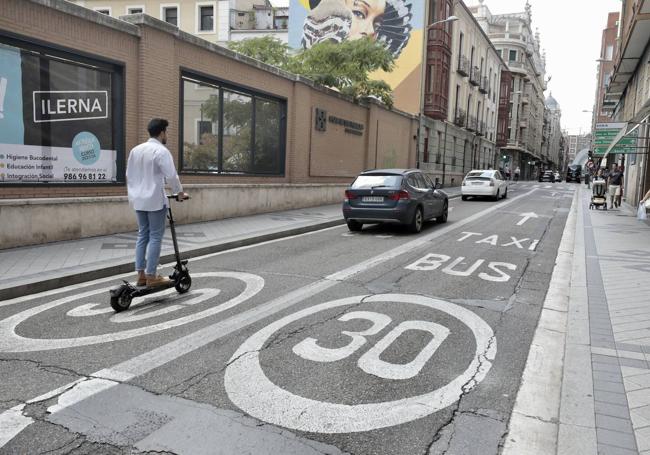 Un patinete por el carril destinado a vehículos. Al lado, el carril bus taxi.