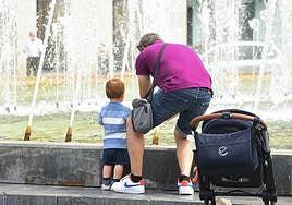 Un hombre se refresca junto a su hijo en la fuente de la Plaza de Zorrilla de Valladolid, en una imagen de archivo.