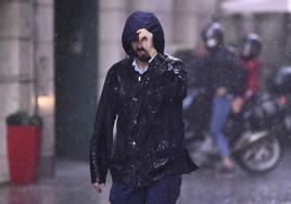 Un joven intenta protegerse de la lluvia durante una de las últimas tormentas en Valladolid.