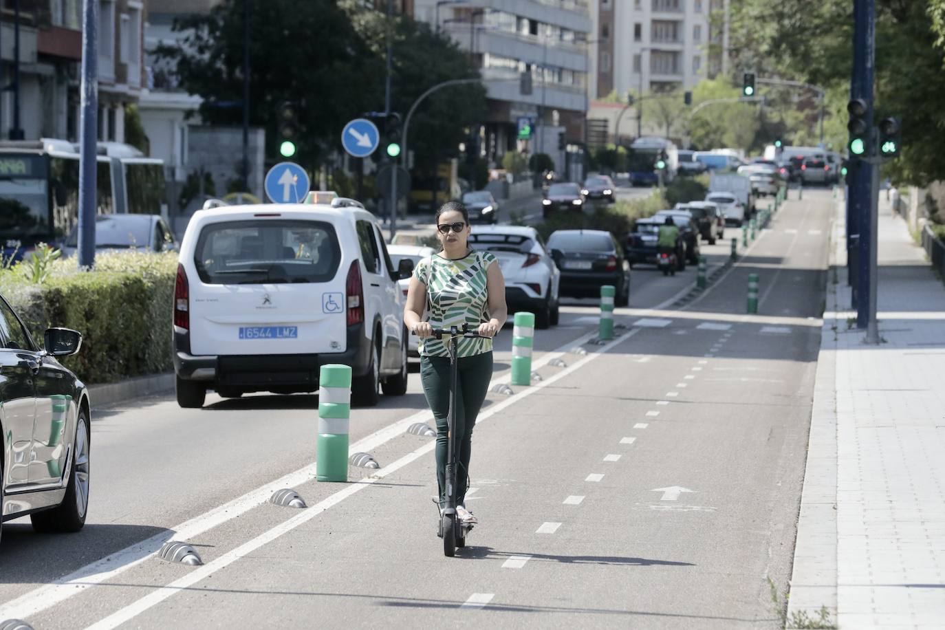 Una mujer circula en patinete por el carril bici de Isabel la Católica.