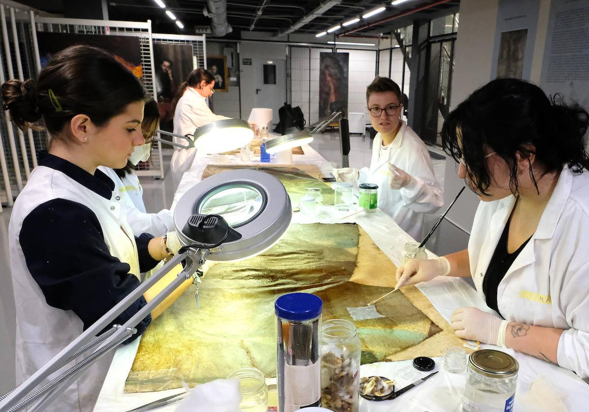 Varias alumnas de la Escuela de Arte trabajan en la restauración de los lienzos de Martí y Monsó.