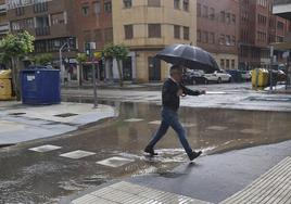 Un hombre salva los charcos formados en República Argentina, tras una tormenta el pasado 19 de junio.