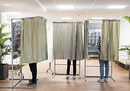 Electores de Valladolid preparan su papeleta en un colegio electoral.