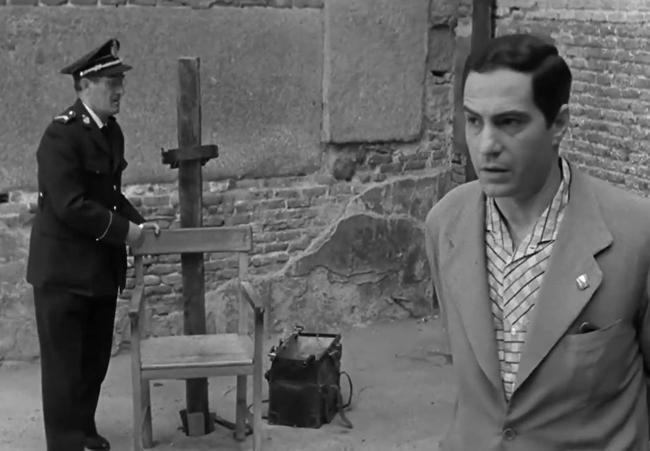 Fotograma de la película El Verdugo (1963), de Berlanga. El funcionario preparando del garrote y la silla donde sentarán al reo.