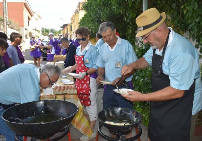 Integrantes de la peña El Belén de Cigales fríen huevos para dar de almorzar a vecinos y visitantes.