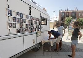 Unos vecinos de Paredes escriben sus datos antes de hacerse la fotografía.
