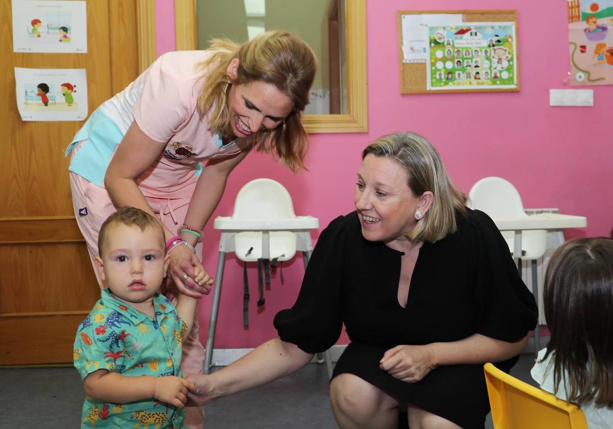 La consejera de Familia e Igualdad de Oportunidades, Isabel Blanco, juega con un niño en la escuela de Baltanás.