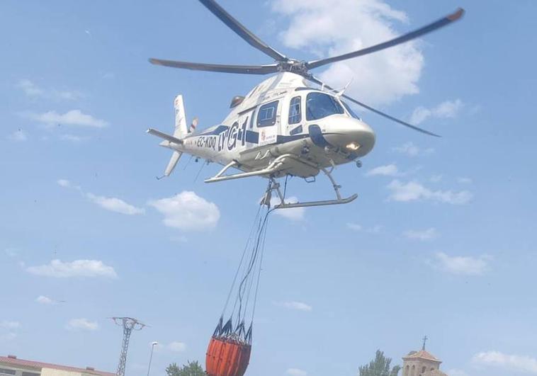 Un helicóptero lleva agua para desparramarla sobre el incendio en la zona de Ochando y Balisa.