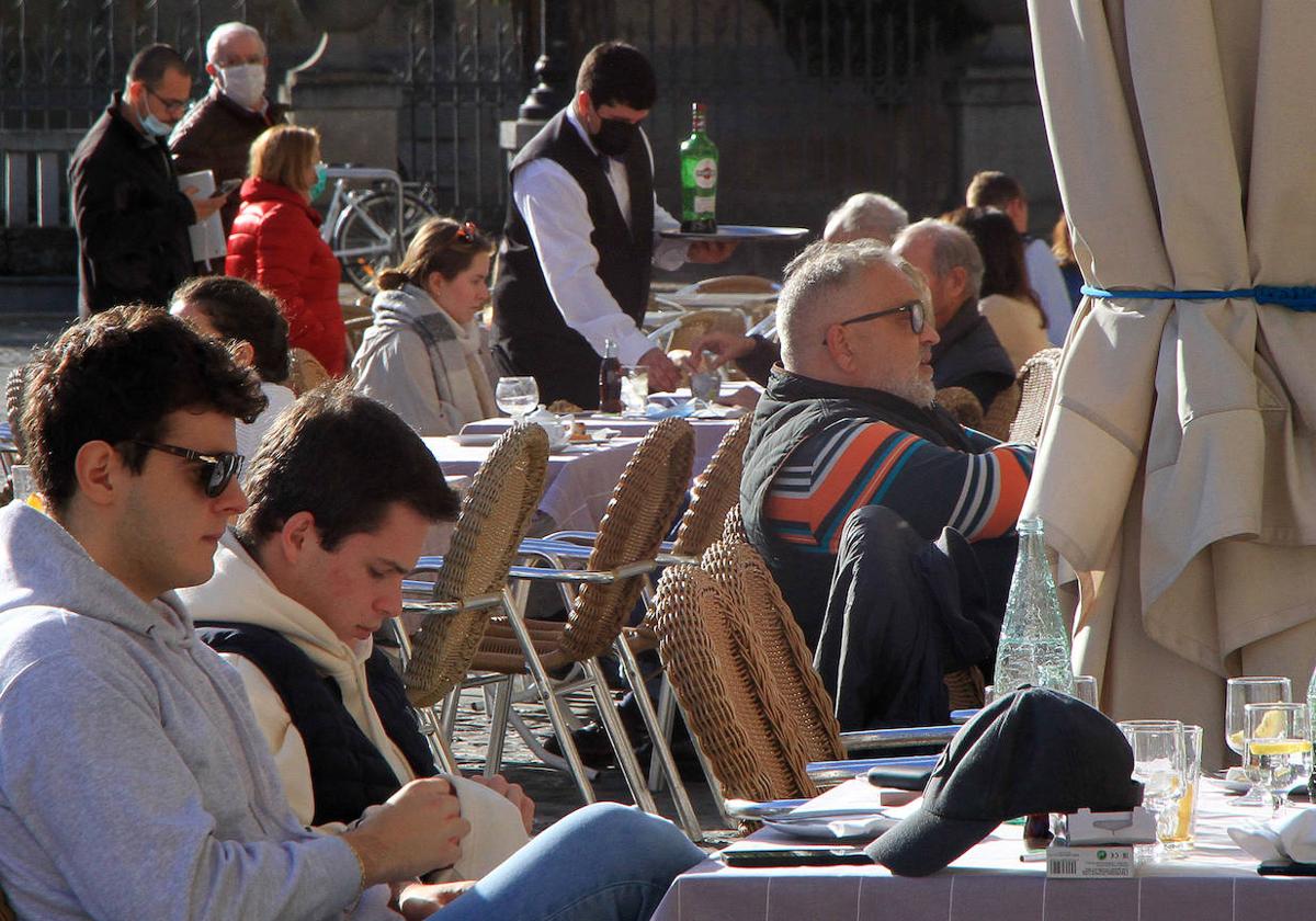 Un camarero atiende las mesas de una terraza de un restaurante en la Plaza Mayor de Segovia.