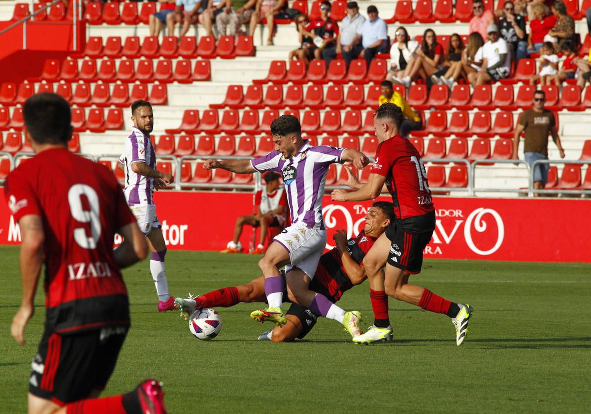 Raúl Moro, perseguido por dos defensores del Mirandés.