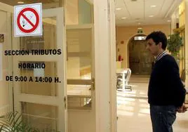 Un ciudadano espera en la puerta de la oficina de Tributos del Ayuntamiento de Segovia.