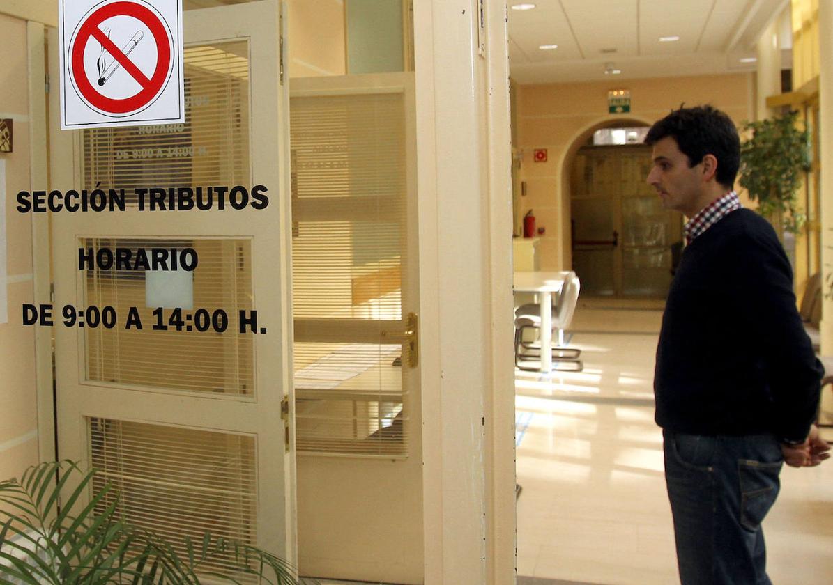 Un ciudadano espera en la puerta de la oficina de Tributos del Ayuntamiento de Segovia.