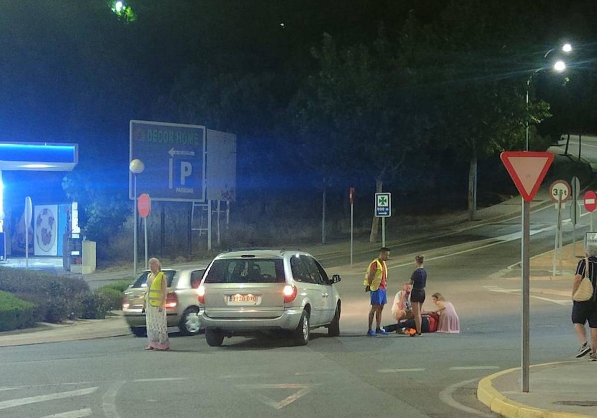 Varias personas atienden al repartidor en la rotonda de la avenida del Sotillo.