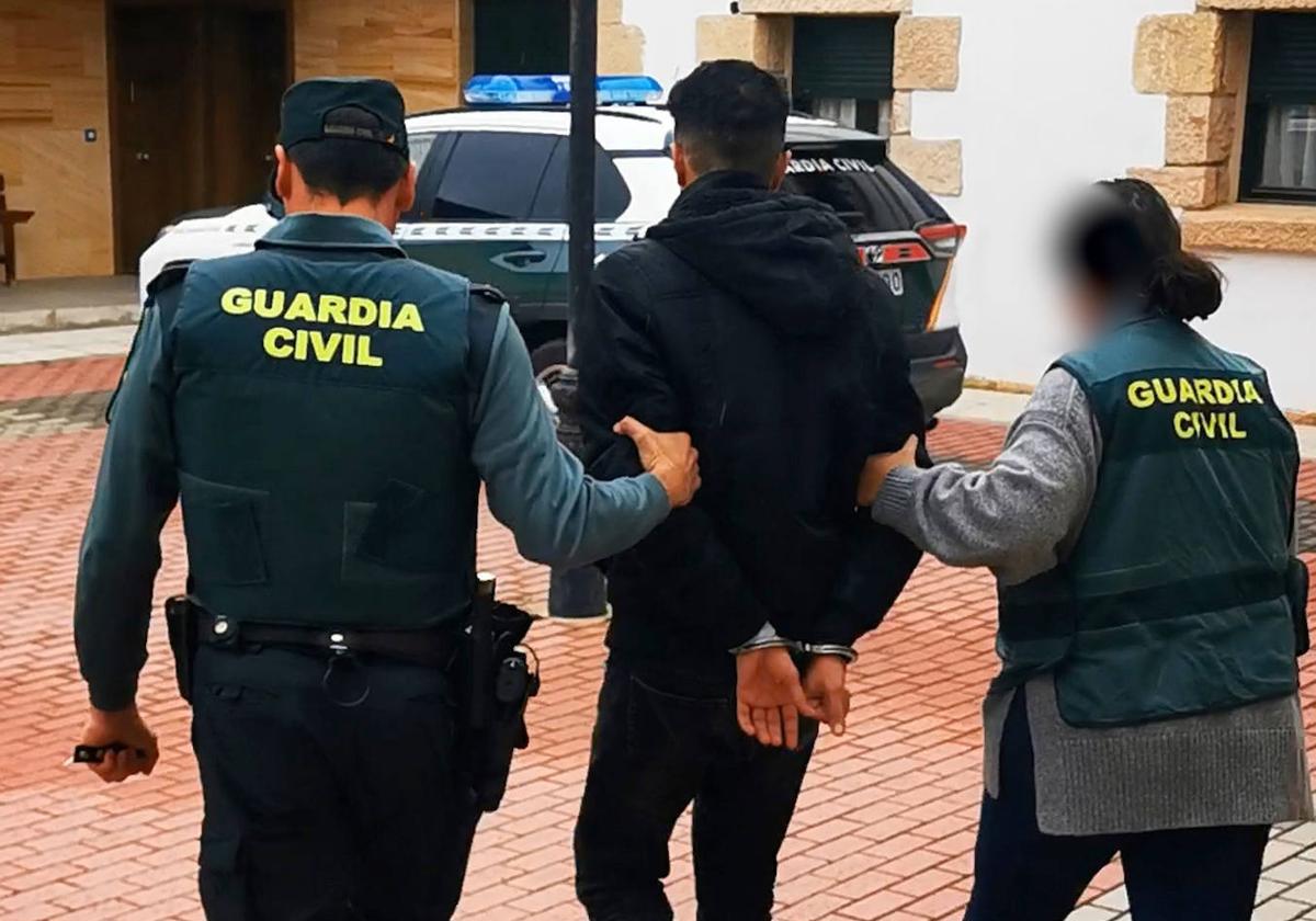 Dos guardias civiles escoltan a un hombre detenido por unos robos en la provincia de Segovia.