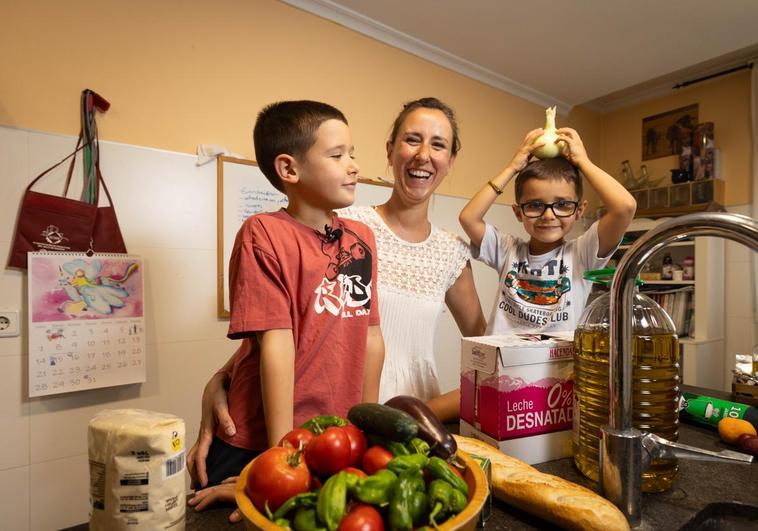 Sara con sus dos hijos colocando la compra