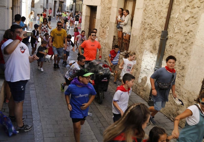 Los niños se divierten corriendo delante de un carretón.