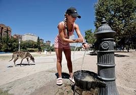 Una mujer se refresca en una fuente de la playa de Las Moreras en Valladolid.