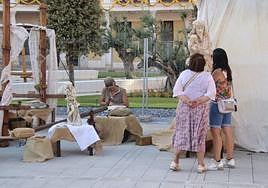 Dos personas observan el trabajo de un cantero.