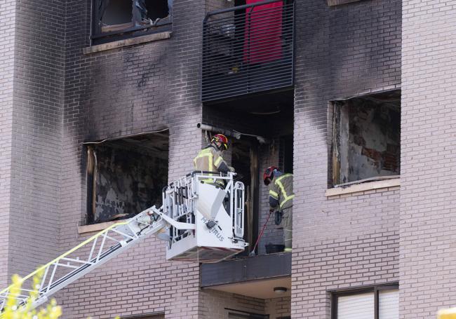 Los bomberos trabajan en la terraza en la que Javier Redondo rescató a su vecino tras la explosión.