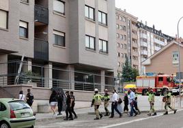 Policías y bomberos acompañan a los vecinos a recoger sus enseres en el bloque afectado de la calle Juan de Valladolid.
