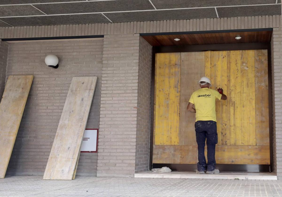 Un operario blinda el portal de acceso al número 23 de la calle Juan de Valladolid.