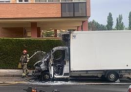 Un bombero refresca el camión para evitar que el incendio se reproduzca.