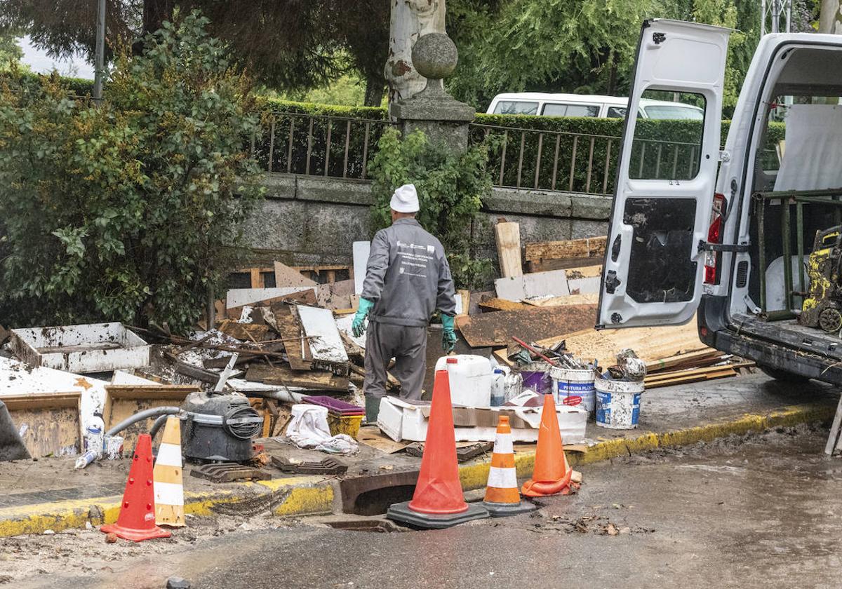 Un hombre realiza labores de limpieza en un garaje anegado por el barro tras la inundación ocurrida el lunes.