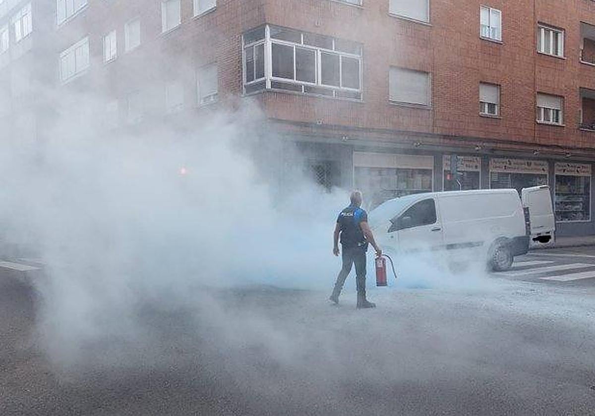 Un agente junto a la furgoneta qyue ha sufrido el incendio.