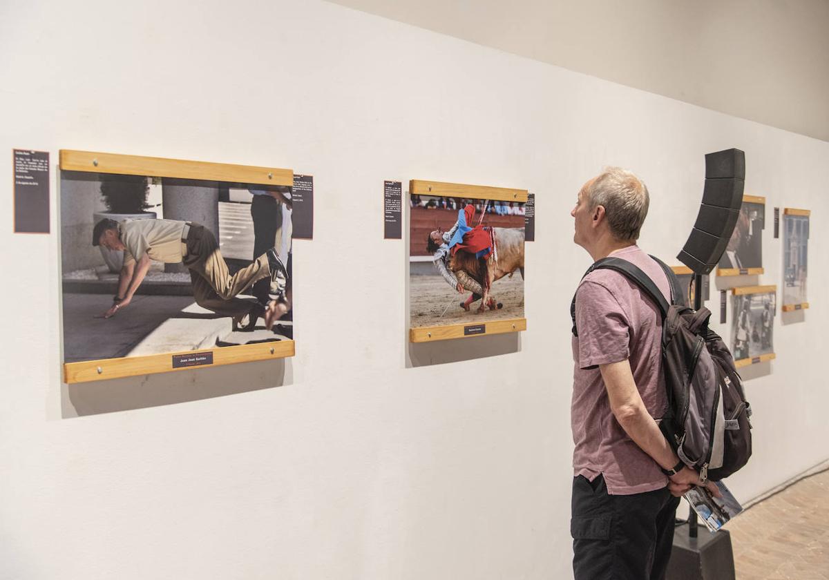 Un hombre contempla varias de la fotografías de la exposición.