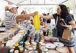 Una mujer compra en uno de los puestos de la Acera de Recoletos.