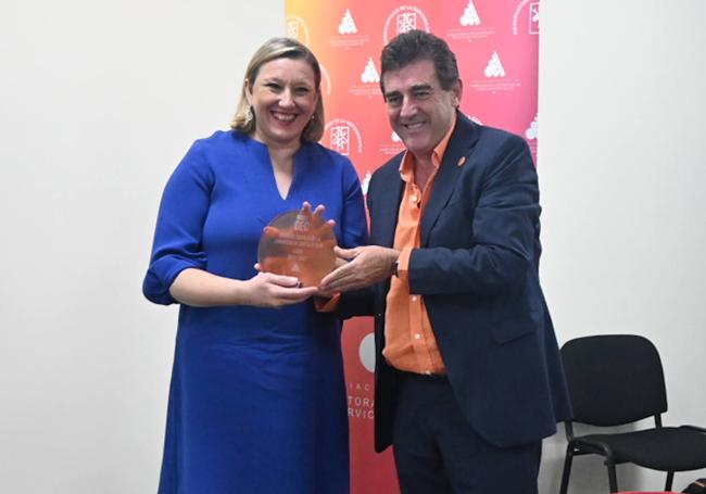 La consejera de Familia, Isabel Blanco, recibe el premio de manos de José Manuel Ramírez.