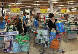 Clientes pasan por caja en un supermercado.