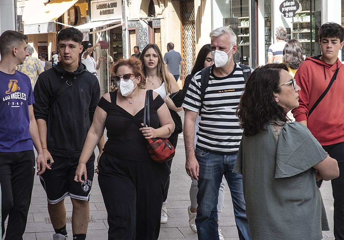 Dos personas pasean con mascarilla por el centro de la ciudad de Segovia.