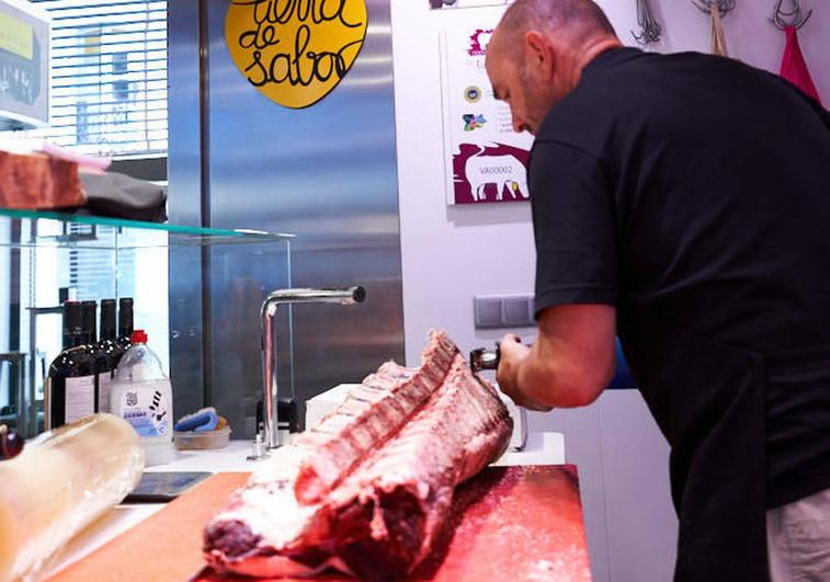 Javier de las Heras corta carne en su puesto del Mercado del Val.