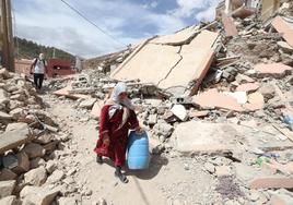 Una mujer camina entre los escombros de los edificios dañados en la aldea de Imi N'Tala, tras el terremoto de Marruecos.