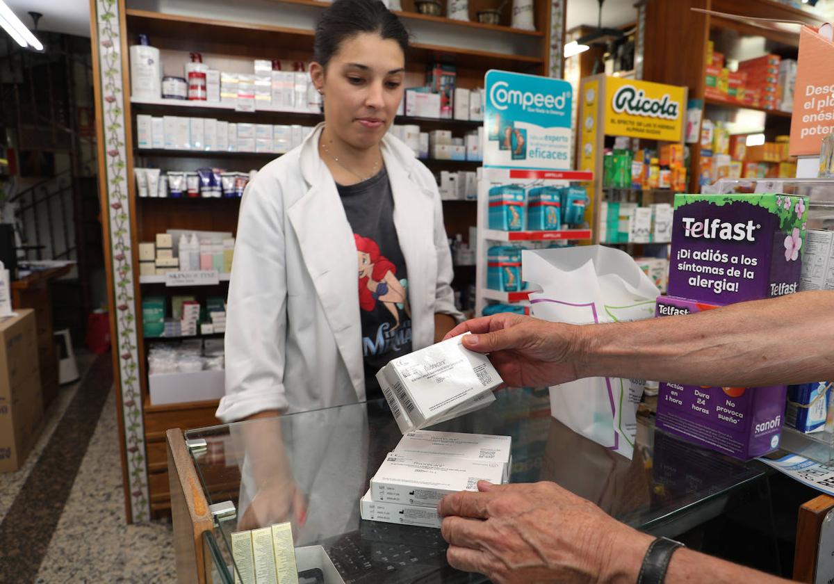 Judith López vende unos test en la farmacia de María Josefa Herrero, en la esquina de Barrio y Mier.