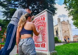 Marina Carvajal (Valladolid, 2002) y Román Olmos Horbunov (Sambir, Ucrania, 2001) decoran un cuadro eléctrico situado entre la calzada y un jardín de la plaza de San Pablo.