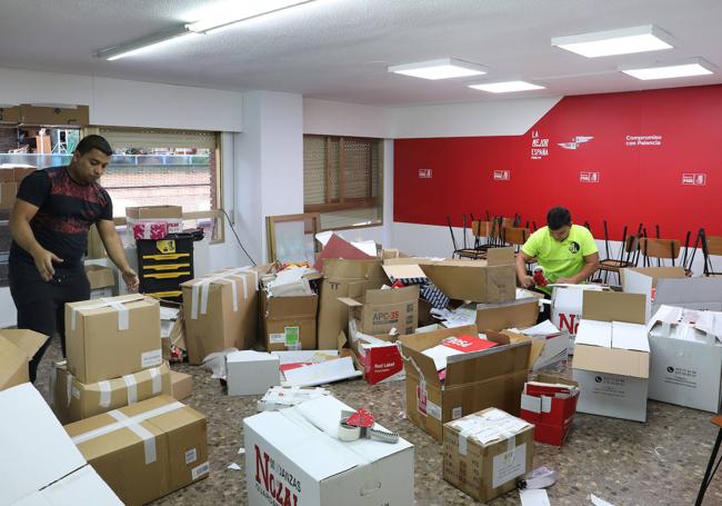 Los trabajadores de la empresa de mudanzas recogen cajas en Jacinto Benavente.