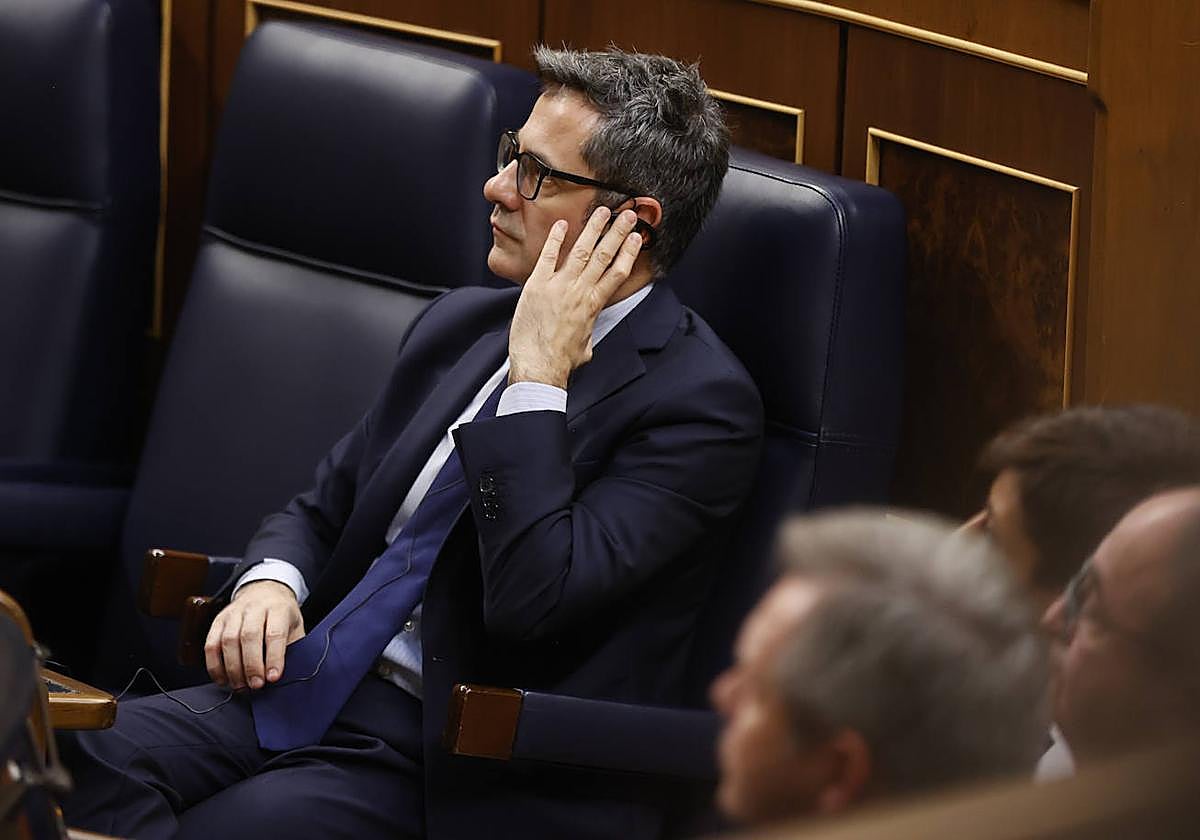 l ministro Félix Bolaños escucha por el pinganillo durante la sesión plenaria en el Congreso.