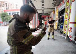 El bombero Álvaro Paramio graba un vídeo mientras un compañero del parque central realiza maniobras.