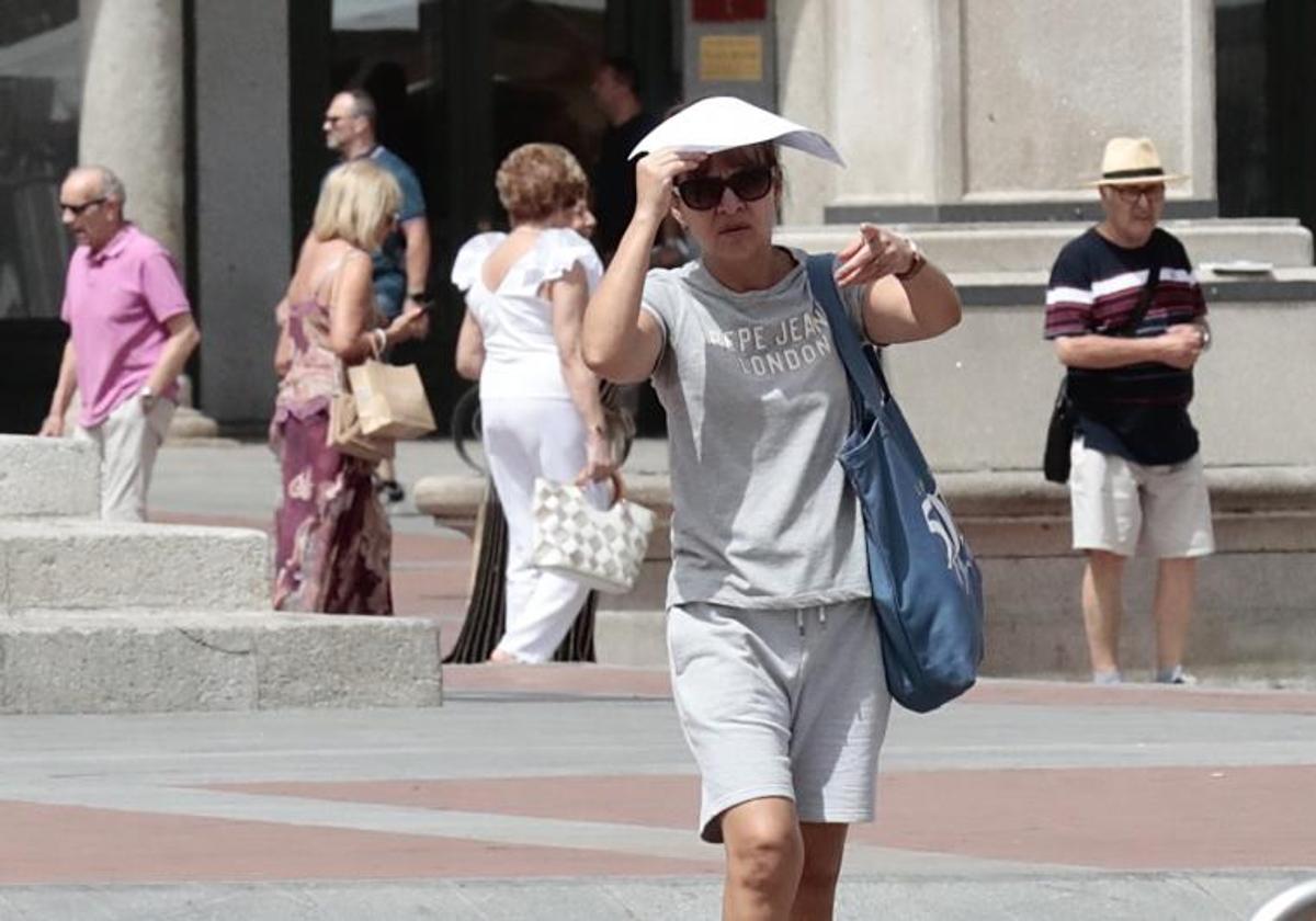 Viandantes se protegen del calor en la Plaza Mayor el pasado agosto.