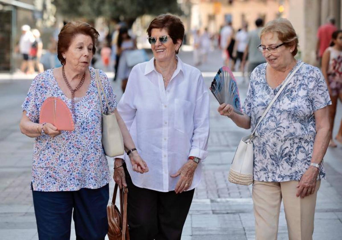 Tres mujeres se abanican mientras pasean por una calle de Valladolid el pasado mes de agosto.