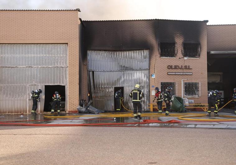 Los bomberos trabajan en el incendio de varias naves en Santovenia.