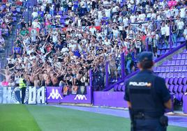 Los aficionados del Burgos cantan en pie hacia la grada del Pucela, custodiados por la Policía Nacional y la seguridad.