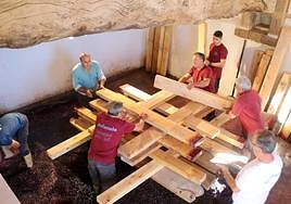 Varios socios preparan el castillo para el prensado de la uva.