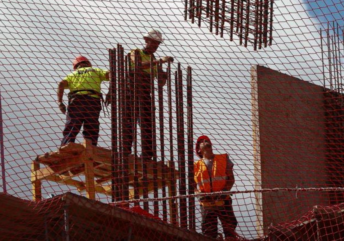 Trabajadores de la construcción realizan un encepado con ferralla en un edifico residencial.