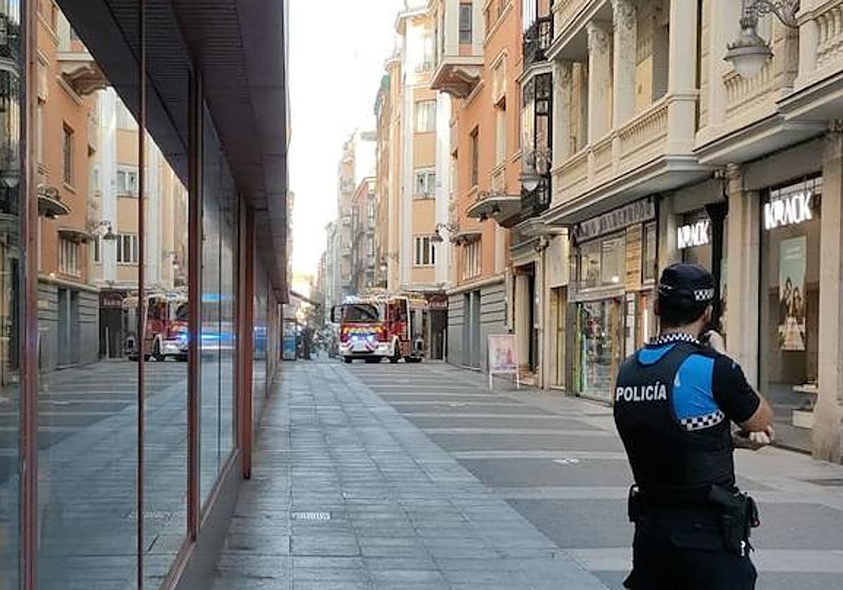 Un policía local vigila la calle mientras los Bomberos trabajan.