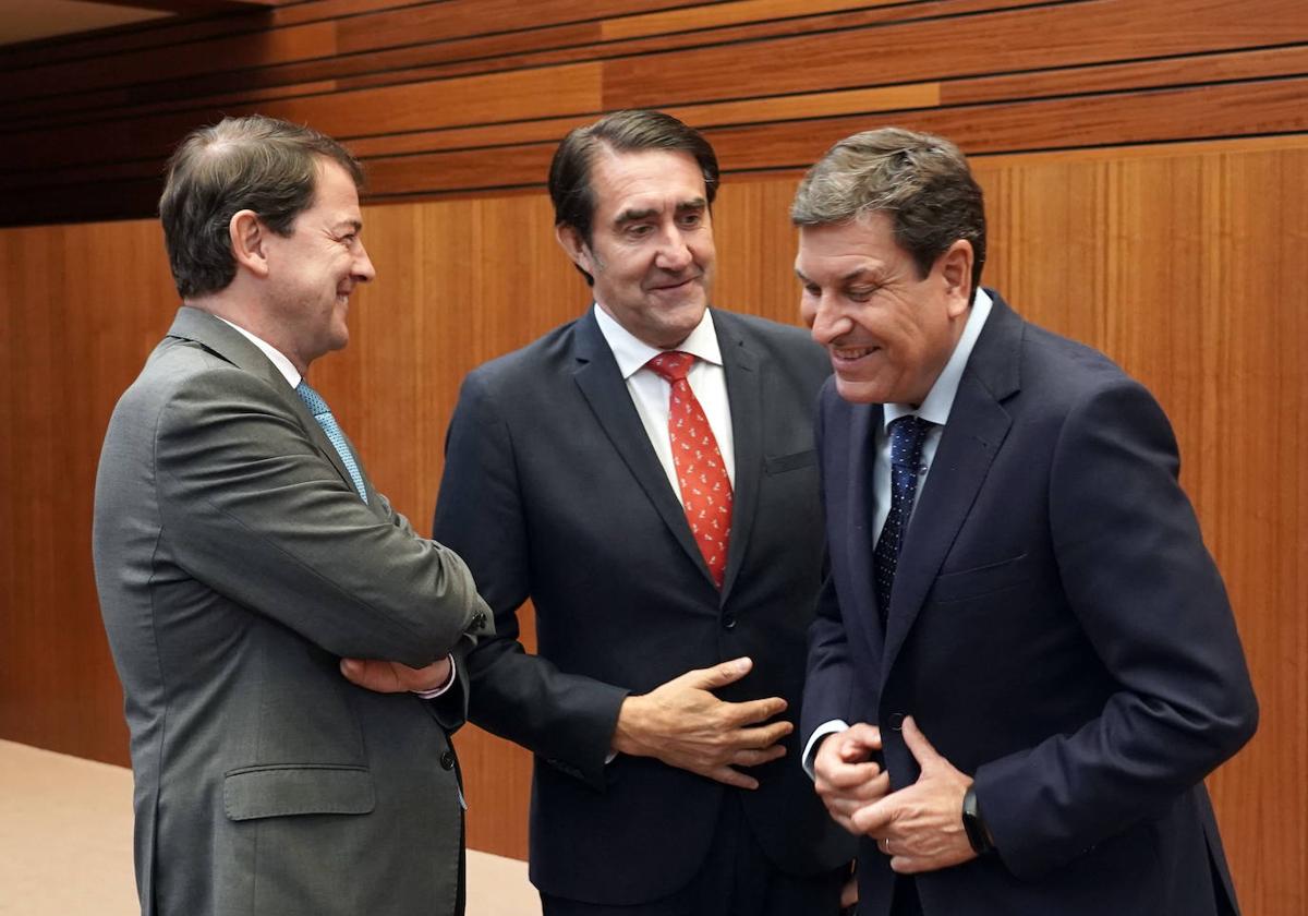 Fernández Mañueco conversa con los consejeros populares Suárez-Quiñones y Fernández Carriedo, en el hemiciclo de las Cortes.