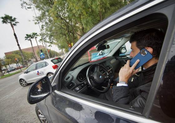 Un conductor habla por el teléfono móvil.