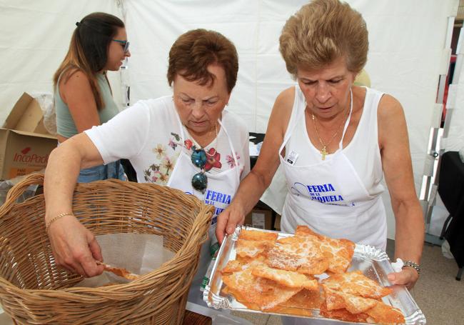 Dos mujeres colocan hojuelas en una bandeja.